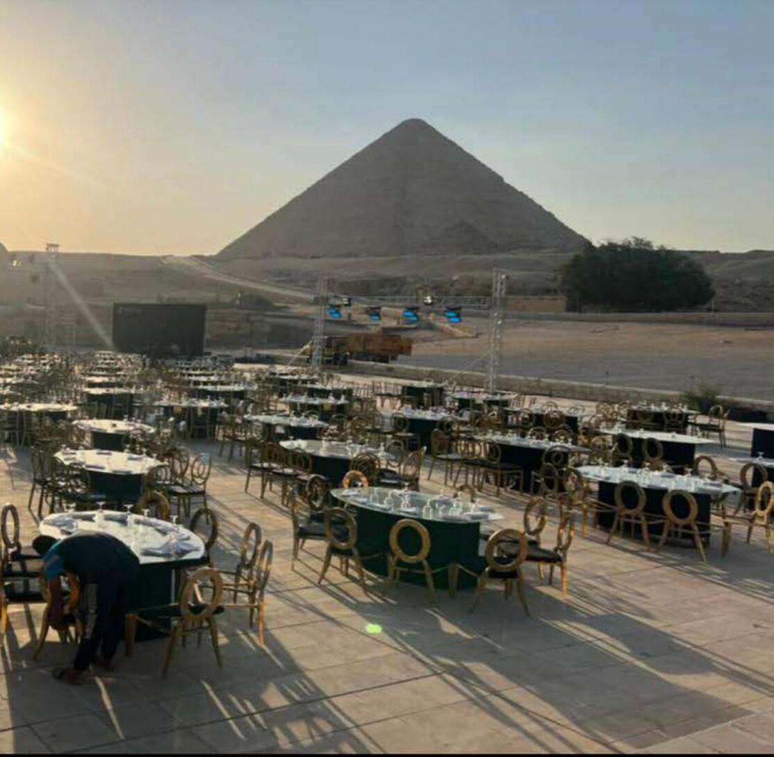 Gala dinner setup facing the Great Pyramid of Giza at sunset