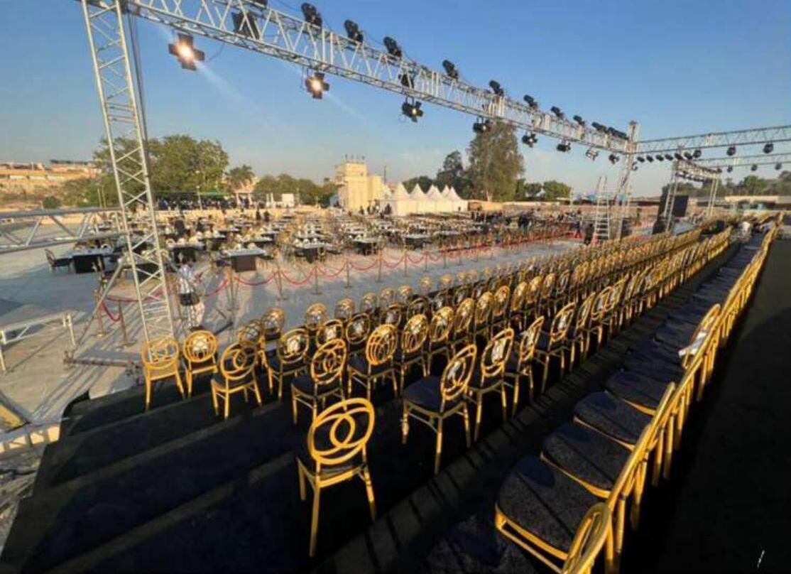 Grand staged event with lighting truss and gold seating at Giza